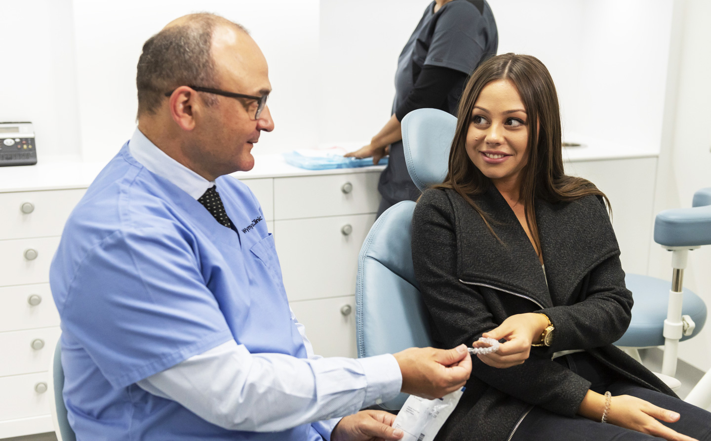 Smiling dentists talking to patient